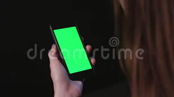 女人拿着绿色屏幕放大的手机视频的预览图