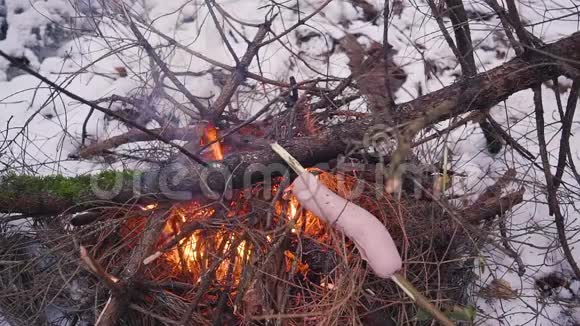 冬天森林里篝火上烤香肠视频的预览图