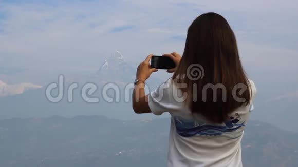 女人在手机上拍山的照片视频的预览图