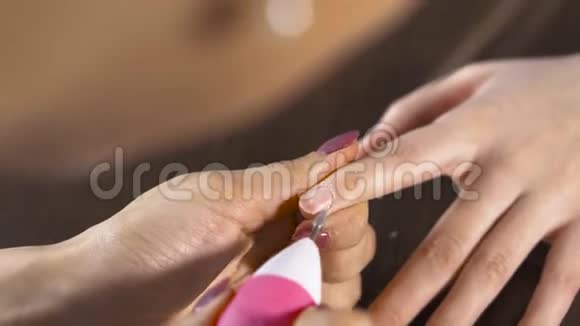将指甲油涂在女性指甲上的美容师的特写镜头视频的预览图