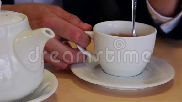 男人的手紧紧地把茶倒在杯子里搅拌勺子视频的预览图