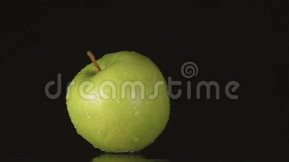 黄色一个绿色的苹果卷在黑色的背景上站着视频的预览图