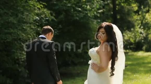 新婚快乐的新娘和新郎一起摆姿势玩得开心优雅的新郎戴着婚纱他们俩视频的预览图