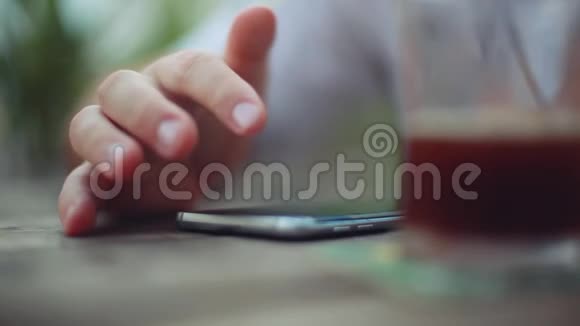 男性手关闭使用智能手机应用程序短信在夏季户外咖啡馆1920x1080视频的预览图