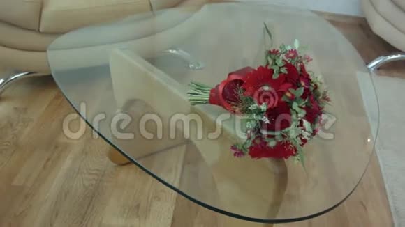 红色的花束躺在透明的桌子玻璃上视频的预览图