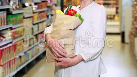 杂货店里有一袋蔬菜的老妇人视频的预览图