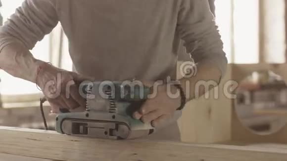 老木工用皮带打磨机仔细加工木板制造商视频的预览图
