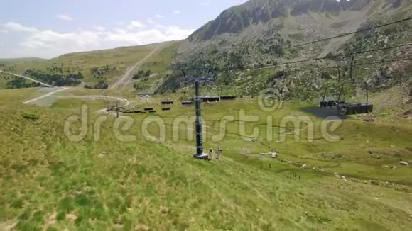 夏季绿色滑雪坡和升降机的空中镜头视频的预览图
