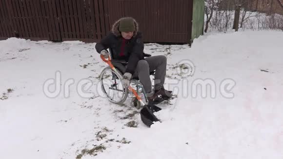 坐轮椅的残疾人用雪铲干活视频的预览图