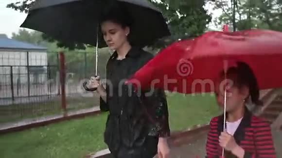 母女俩在大雨中走在街上视频的预览图
