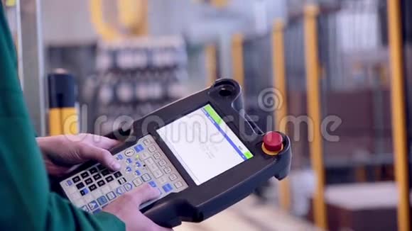 工人操作机器人手臂装载和装配产品工业控制台遥控武器视频的预览图