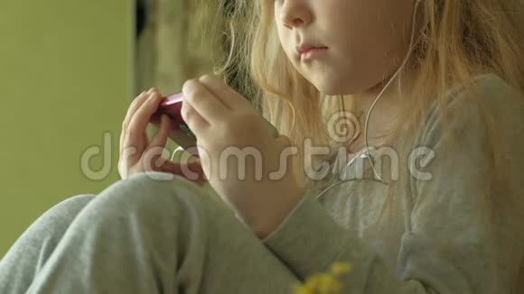 坐在窗户上的小女孩用电话视频的预览图