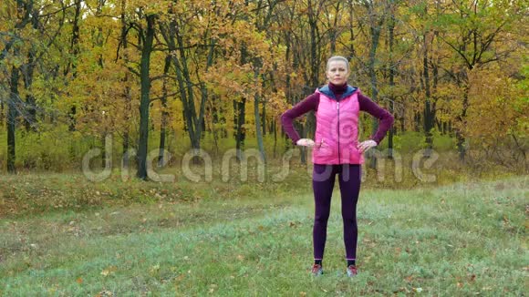 慢动作秋天穿着运动服的美丽的健身运动女孩从运动水瓶中喝水或等渗饮料视频的预览图