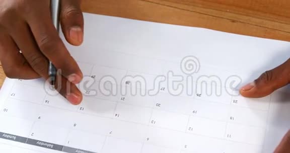 在日历上用钢笔标注人的特写视频的预览图