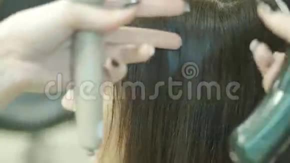 一个在美容院留着深色长发的女人和大师一起做发型视频的预览图