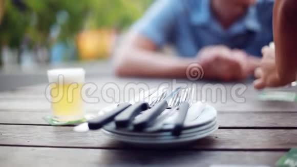 餐桌餐盘餐叉餐刀由人手放在木桌上男性双手合拍视频的预览图