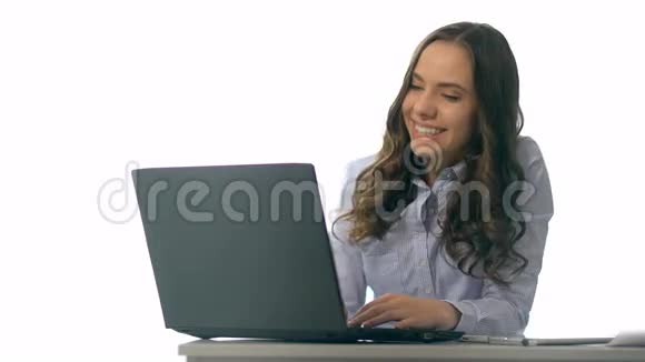 微笑着年轻女商人坐在办公室桌上拿着笔记本电脑视频的预览图