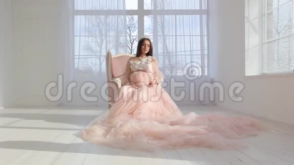 穿着粉红色长裙的年轻怀孕少女视频的预览图