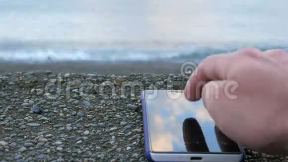 手机是关于海洋的卵石滩的找你照片的人特写镜头视频的预览图