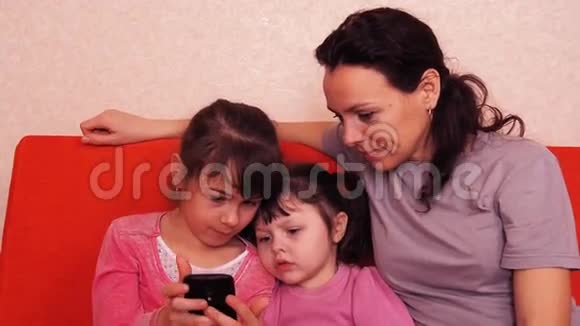 妈妈和女儿玩手机幸福的家庭玩手机视频的预览图