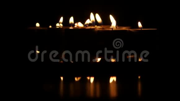 一群在黑色背景上燃烧的小蜡烛关门视频的预览图