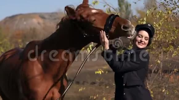 带着马的女孩的肖像骑马在秋天的森林里视频的预览图