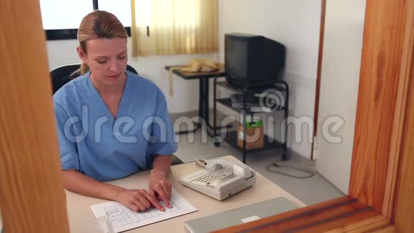 护士在前台查看文件视频的预览图