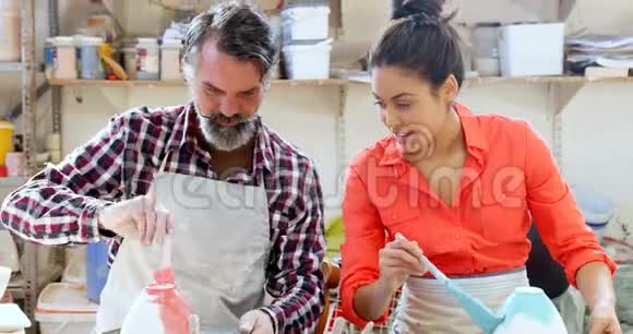 男女陶工绘画陶瓷碗4k视频的预览图