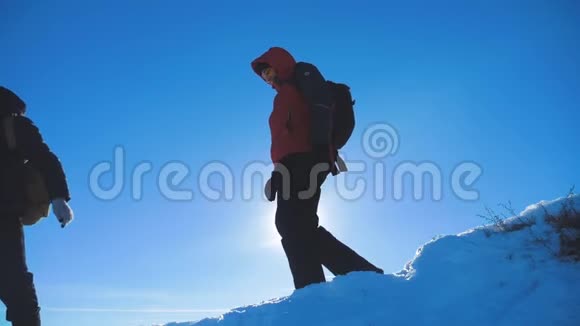 男子旅行者在冬季登山剪影阳光慢动作视频旅行冒险冬季生活方式视频的预览图