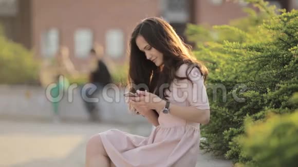 年轻美丽的女人在街上打电话留言视频的预览图
