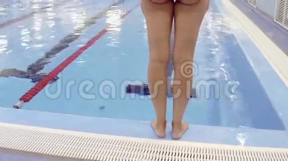 女性游泳者准备和跳进游泳池视频的预览图