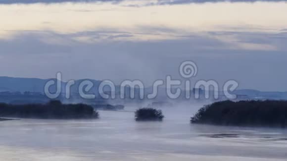 清晨的薄雾笼罩着河水清晨的雾河晨湖上的景观雾视频的预览图