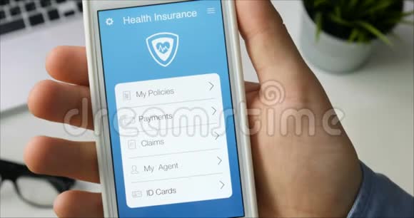 用坐在办公桌前的智能手机应用支付医疗保险视频的预览图