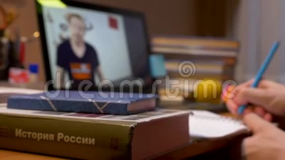 一个年轻人坐在桌子旁写着笔记本视频的预览图