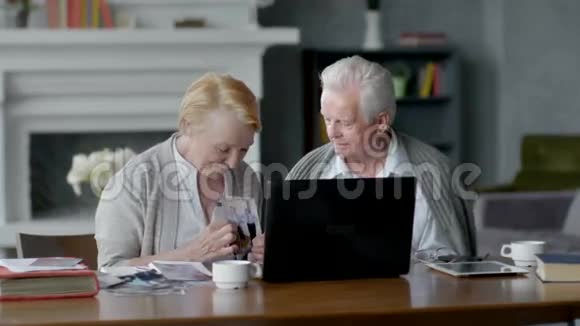 网络摄像机一对老夫妇在舒适的客厅里与家人在互联网上交流的乐趣视频的预览图