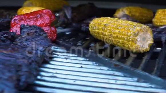 烤烧烤炉上的羊肉排骨和蔬菜烤肉和玉米慢动作视频的预览图