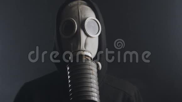 在黑暗的房间里戴着防毒面具的男人视频的预览图