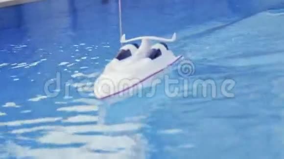 RC船正在大游泳池里航行玩具船周围没有人室外拍摄暑期欢乐的气氛回来视频的预览图