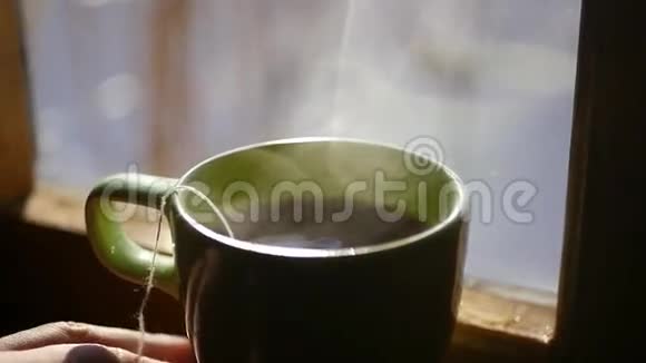 在蓝天的背景下沸水在阳光的照耀下在一扇窗户附近酝酿着一杯烧茶视频的预览图