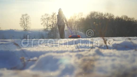 年轻快乐的女人在冬天缓慢地穿过太阳在山上奔跑1920x1080视频的预览图
