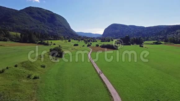 4K早上在绿波欣吉湖谷上空飞行人们骑自行车在小径上朱利安阿尔卑斯山的斯塔拉福齐纳村视频的预览图