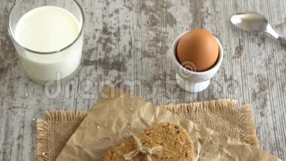桌上的饼干软煮鸡蛋和一杯牛奶在乡村的木制桌子上道具4K视频的预览图