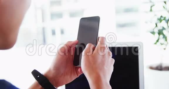 在办公室工作的人用带手提电脑的手机和带着智能手表视频的预览图