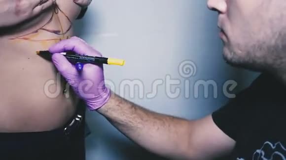 一位年轻的纹身艺术家描绘了一个美丽女孩身上的纹身区域视频的预览图