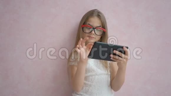 可爱的小女孩用平板电脑视频的预览图