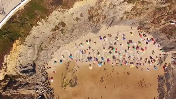 人们在海滩的鸟瞰图上遮阳伞下日光浴视频的预览图