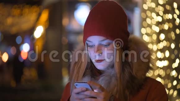 晚上在户外用手机的女孩视频的预览图