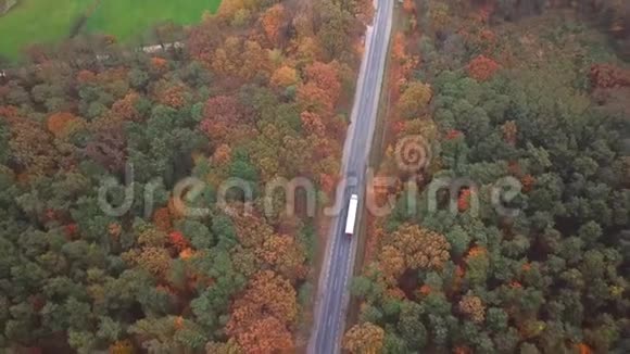 在美丽的秋天傍晚在横跨全国的高速公路上在集装箱半卡车的高空飞行交通视频的预览图