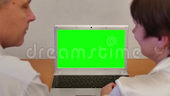 男人和女人带绿色屏幕笔记本电脑视频的预览图