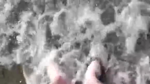 人的脚被海浪冲走把它们埋在沙子里顶部视图视频的预览图